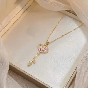 Nahaufnahme einer zarten goldenen Herzschlüssel-Halskette mit funkelnden Zirkoniasteinen.