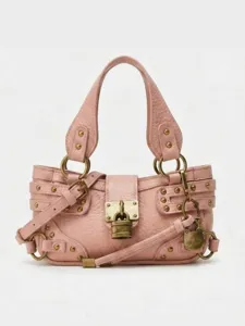 Sac bandouliere de moto en cuir rose avec cadenas en metal, clous et sangle ajustable.