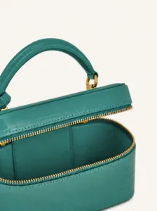 Green crocodile pattern mini vanity bag with top handle and zip closure for daily commute.