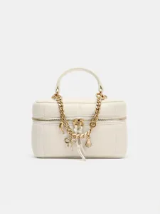 White leather vanity bag detail, featuring gold chain strap and cute metal charms.