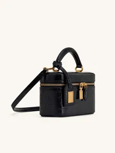 Detailed view of black crocodile embossed mini vanity box bag with gold tone hardware and handle.