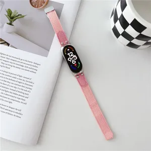 Λεπτομερής εικόνα ροζ πλεγμένου λουριού smartwatch σε σκηνικό με φυτό και κούπα.