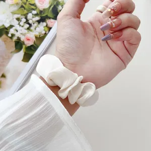 Nahaufnahme eines weißen Chiffon Scrunchie Uhrenarmbands am Handgelenk getragen.