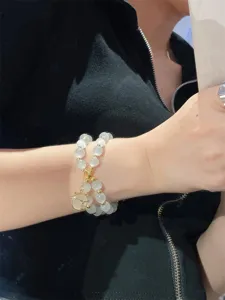 Charmante kattenoog kralenarmband detail met schattige kattenhanger, elegante damessieraad.