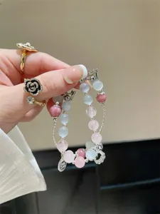 Vue détaillée du bracelet de montre connectée en pierre œil-de-chat avec perles roses.
