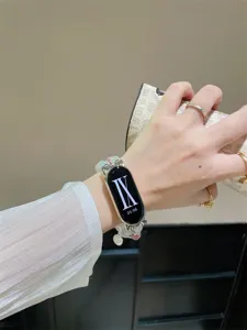 Vue de détail d'un bracelet de montre connectée en perles d'œil de chat, élégant et chic.