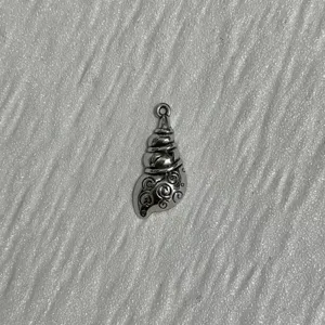 Pendentif coquillage argenté avec des détails en spirale délicats, idéal pour les bijoux DIY.