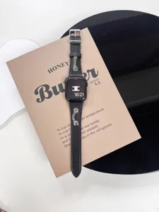Primo piano del cinturino in pelle nera per Apple Watch con catena in metallo vintage.