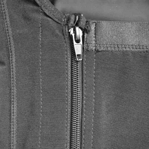 Close-up detail shot of black shapewear zipper, highlighting elastic fabric and sewing.