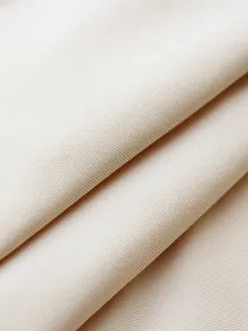 Detailed view of beige shapewear fabric, showing high elasticity and fine ribbed texture.