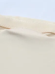 Close-up detail of nude shapewear fabric showing fine stitching and smooth texture.