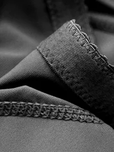 Macro detail of high-elastic black shapewear fabric with fine stitching and neat hems.