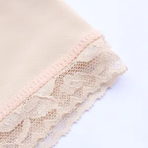 Close-up detail of women's shapewear lace trim, breathable nude fabric texture macro view.