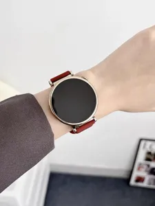 Detailed view of a sleek round smartwatch with vibrant red strap worn gracefully on wrist.