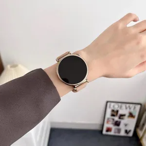 Close-up view of the smartwatch worn on wrist with pink strap and round gold case design.
