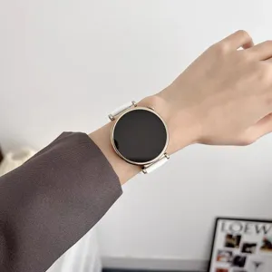 Close-up detail shot of smartwatch with white silicone strap and gold case on wrist.