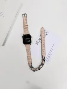 Detailansicht des stilvollen Tweed- und Metallketten-Apple-Watch-Armbands im Doppel-Design.