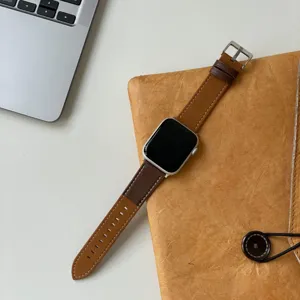 Nahaufnahme des zweifarbigen Echtleder-Uhrenarmbands mit weißen Nähten und Silberschnalle.