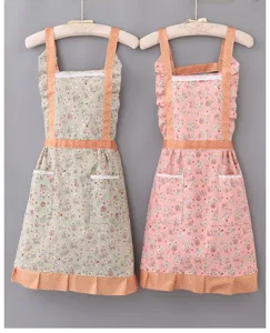 Floral kitchen apron with polka dot straps and pockets, cute pastoral style cooking wear detail.