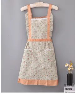 Detailed view of pastoral floral apron with orange polka dot pockets and lace trim design.