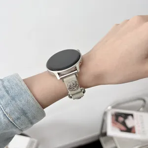 Primo piano del cinturino di ricambio in pelle per smartwatch con ciondolo a rosa argento.