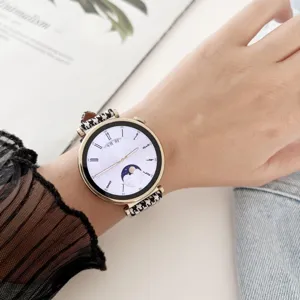 Detail view of women's smartwatch with houndstooth fabric strap and gold case on wrist.
