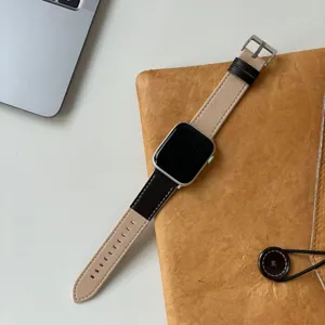 Detailansicht des zweifarbigen Echtleder-Uhrenarmbands in Beige und Braun mit Silberschnalle.