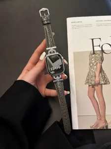 Detail of luxury grey crocodile leather Apple Watch strap with diamond H-shaped connectors.