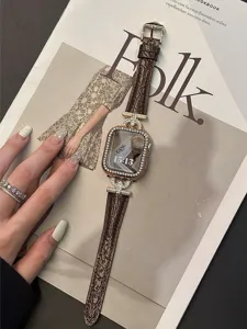 Close-up of brown crocodile pattern leather watch band with sparkling diamond gold case.