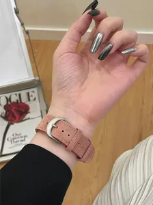 Gedetailleerd overzicht van roze suède horlogeband met metalen gesp en zachte textuur.