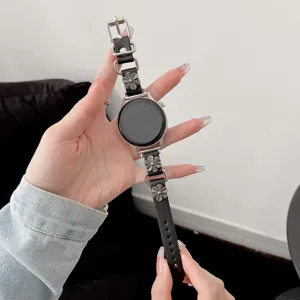 Cinturino per orologio in pelle nera e metallo stile punk con ciondoli floreali vista dettagliata.
