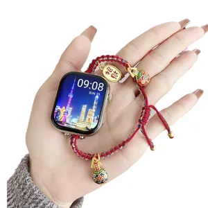 Red woven braided strap for Apple Watch with golden lucky charms and colorful pendants.