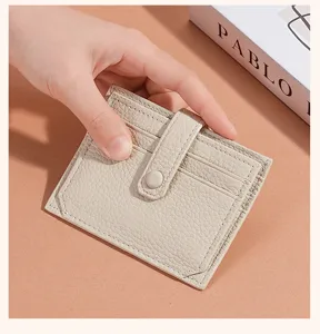 Compact genuine leather card holder in beige with snap closure and multi card slots.