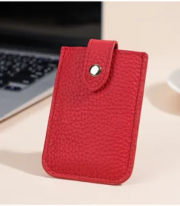 Detailed view of the red leather card holder featuring a snap button closure and slim profile.