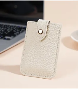 Compact beige genuine leather card holder with snap closure for daily use minimalist aesthetic.
