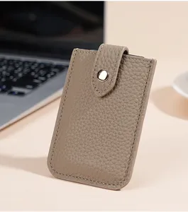 Minimalist genuine leather card holder detail shot, showing exquisite lychee texture and snap.