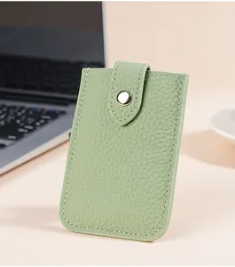 Light green leather card holder detail, slim mini card case with snap button closure design.