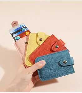 Close-up detail of multi-color leather card holder wallet with snap button and multiple slots.