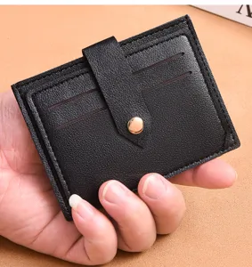 Close-up detail of black leather card holder featuring multiple slots and metal snap button.
