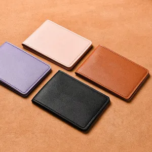 Set di coperture per patente di guida in pelle colorata esposto su sfondo marrone.