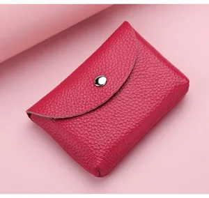 Gros plan sur la texture du porte-monnaie en cuir souple avec détail de bouton-pression.
