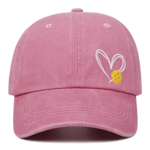 Pink washed baseball cap featuring a cute white heart and yellow pickleball embroidery detail.