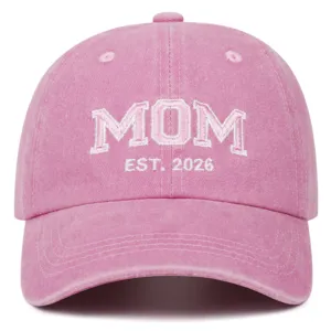 Pink washed dad hat detail, embroidered MOM and EST 2026 text, casual curved brim cap.