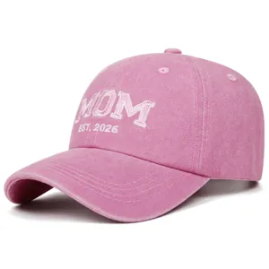 Pink washed cotton baseball cap with embroidered MOM EST. 2026 text for casual outdoor wear.