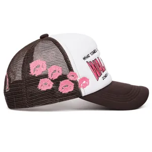 Vista laterale dettagliata del berretto trucker marrone e bianco con ricamo di labbra.