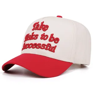 Close-up detail of the red and white baseball cap featuring bold embroidered quote lettering.