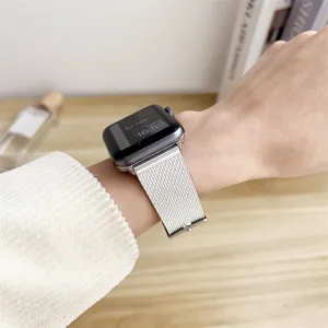 Close-up of silver mesh watch band worn on wrist, premium stainless steel strap detail view.
