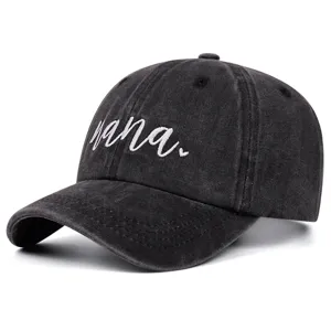 Detailed view of black washed denim baseball cap with white nana embroidery and heart.