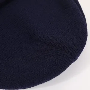 Close-up detail view of dark blue winter knit beanie fabric texture, warm and soft.