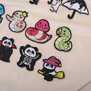 Cute cartoon embroidered patches detail showcasing snake, panda and cat designs for clothing.